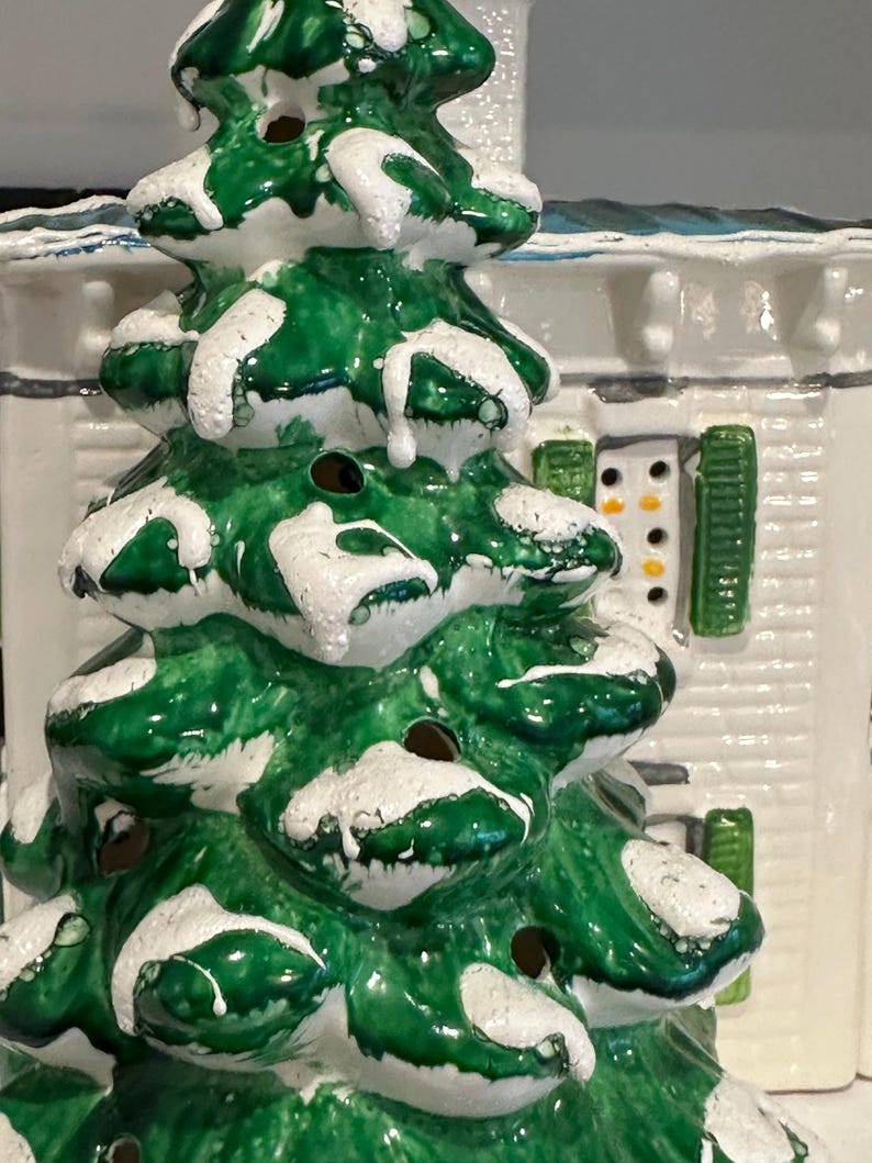 K&ouml;nnte beinhalten: Eine Keramik-Weihnachtsbaumfigur mit gr&uuml;ner und wei&szlig;er Glasur. Der Baum hat einen verschneiten, gefrorenen Look und ist mit kleinen L&ouml;chern verziert.