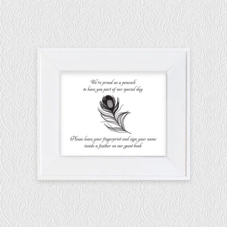 May include: A white framed guest book sign with text and a peacock feather illustration. The text reads, "We're proud as a peacock to have you part of our special day. Please leave your fingerprint and sign your name inside a feather on our guest book."