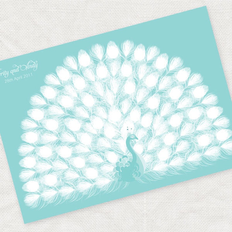 May include: A teal-colored card featuring a white peacock design. The peacock's tail feathers are spread out, and the bird is facing to the right. The text "Serity and Andy" and "28th April 2011" are written in a script font at the top left.