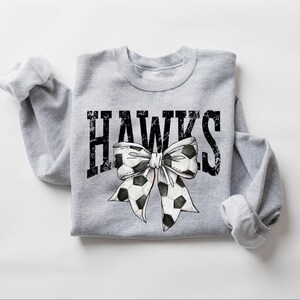 A gray sweatshirt with the word "HAWKS" and a bow graphic printed on it.