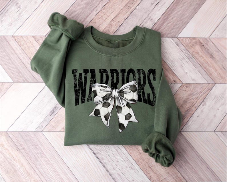 A green sweatshirt with a bow and the word "WARRIORS" printed on it.