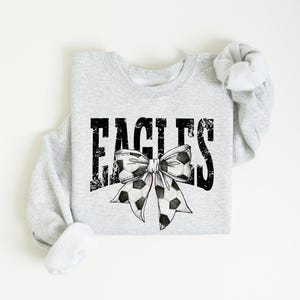 A gray sweatshirt with the word "EAGLES" and a bow printed on it.