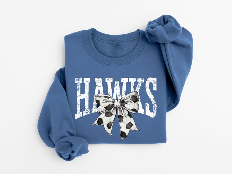 A blue sweatshirt with the word "HAWKS" printed on it, along with a bow design.