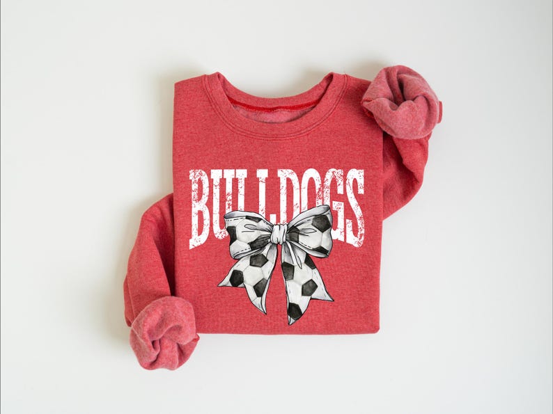 A red sweatshirt with the word "BUILTINS" printed on it, along with a bow design.