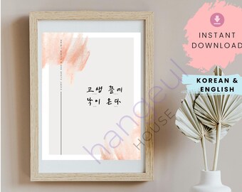 May include: A framed poster with a Korean proverb in black text on a light gray background. The proverb is "고생 끝에 낙이 온다" which translates to "After hardship comes happiness". The poster has a peach-colored watercolor background.