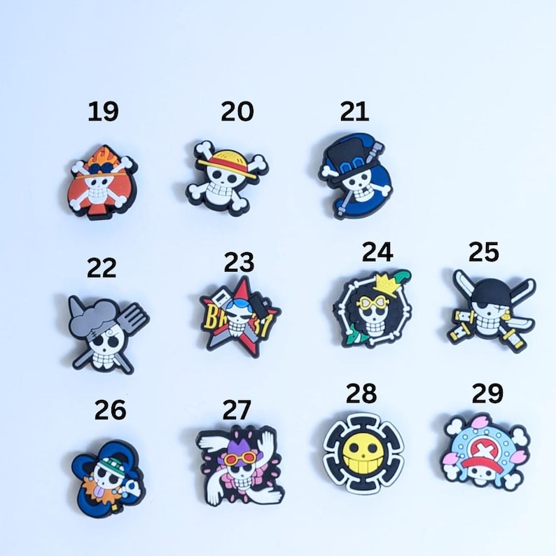 May include: Set of 11 colorful cartoon skull charms with different designs, including a chef, a pirate, and a star. The charms are made of rubber and are perfect for adding a fun and quirky touch to your belongings.
