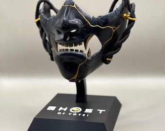 Máscara de lujo de Ghost of Yotei — Black Dye con soporte de exhibición