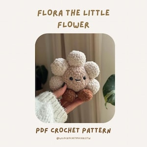 Könnte beinhalten: Ein gehäkeltes Blumenspielzeug mit einem lächelnden Gesicht, beigen Blütenblättern und braunen Akzenten. Der Text "FLORA THE LITTLE FLOWER" und "PDF CROCHET PATTERN" ist auf dem Bild zu sehen.