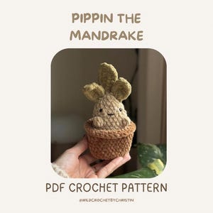 Könnte beinhalten: Eine gehäkelte Alraunenpflanze in einem braunen Topf. Die Alraune hat ein lächelndes Gesicht und grüne Blätter. Der Text "PIPPIN THE MANDRAKE" und "PDF CROCHET PATTERN" sind oberhalb und unterhalb des Bildes zu sehen.