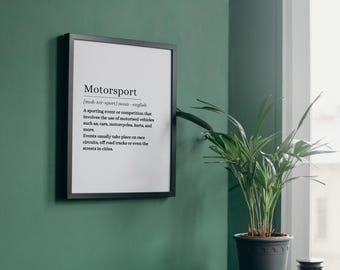 Puede incluir: Una impresión enmarcada en negro con fondo blanco y texto negro que define la palabra "Motorsport". El texto incluye la pronunciación y la definición de la palabra. La impresión está colgada en una pared verde.