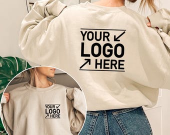 May include: A beige sweatshirt with the text "YOUR LOGO HERE" printed on the back. The sweatshirt is made of a soft, comfortable material and has a relaxed fit.
