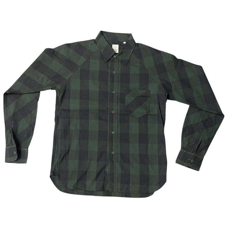 May include: A long-sleeved, button-down shirt in a green and black plaid pattern. The shirt has a single chest pocket and a classic collar. The sleeves have buttoned cuffs.