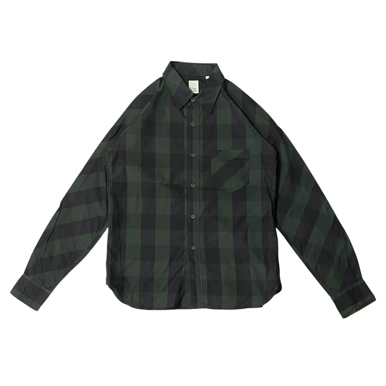 May include: A long-sleeved, button-down shirt in a green and black plaid pattern. The shirt has a single chest pocket on the left side and a classic collar. The fabric appears to be a lightweight material.