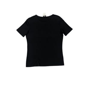 Puede incluir: Una camiseta negra lisa de manga corta con cuello redondo. La prenda est&aacute; hecha de un tejido suave y tiene una etiqueta cerca del cuello. La camiseta se presenta sobre un fondo blanco.