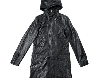 May include: Black leather hooded coat with multiple pockets and button closures. The long coat features a textured surface and a tailored fit. The hood is attached and the sleeves have buttoned cuffs. A stylish outerwear garment.