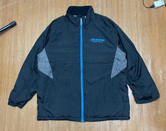 May include: Black zippered jacket with blue accents and gray panels. The jacket has the text "CALSONIC TEAM IMPUL" on the front.