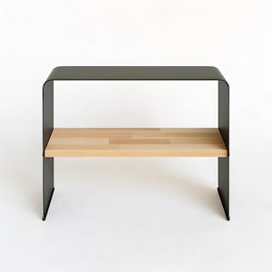 Könnte beinhalten: Modernes, minimalistisches Regal. Die Oberseite und der Rahmen sind schwarz, mit einer gebogenen Oberseite und einem unteren Regal aus hellem Holz. Das Design ist schlicht und funktional, passend für verschiedene Einrichtungsstile.