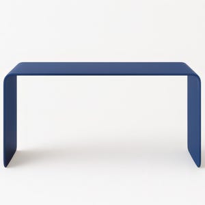 Front view of an ultramarine blue minimalist bent metal table against a solid white background.