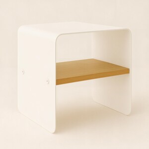 A white metal nightstand with rounded corners and a light wood shelf, viewed from a slight angle against a beige background.