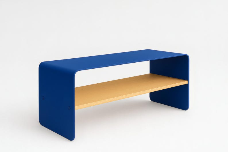 A blue metal bench with rounded corners and a light wood shelf, shown at an angle against a white background.
