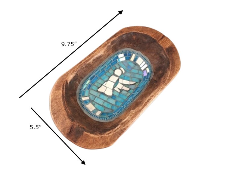 May include: A wooden dough bowl with a blue mosaic design featuring an angel. The bowl measures 9.75 inches long and 5.5 inches wide.