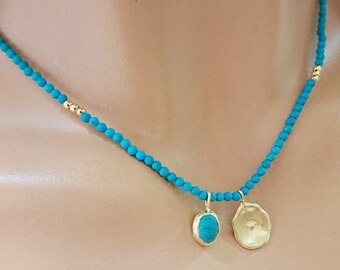 May include: A turquoise beaded necklace with a gold pendant featuring a turquoise stone and a textured gold disc.