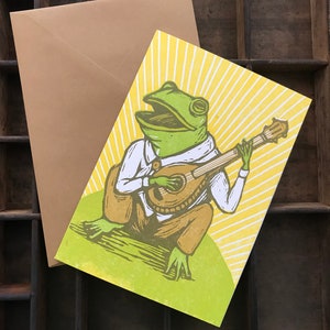 Cartão de felicitações em xilogravura de sapo Pickin