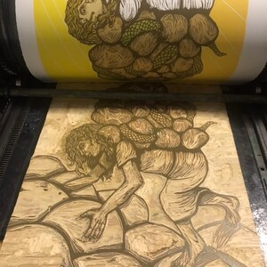 May include: A woodblock print of a person carrying a large, heavy load of rocks on their back. The person is depicted in a stylized, almost cartoonish way, with exaggerated features and a determined expression. The print is done in shades of brown and yellow, and the background is a simple yellow.