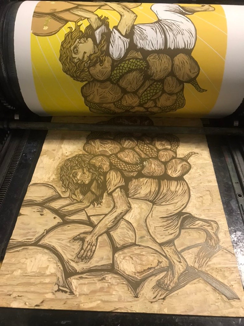 May include: A woodblock print of a person carrying a large, heavy load of rocks on their back. The person is depicted in a stylized, almost cartoonish way, with exaggerated features and a determined expression. The print is done in shades of brown and yellow, and the background is a simple yellow.