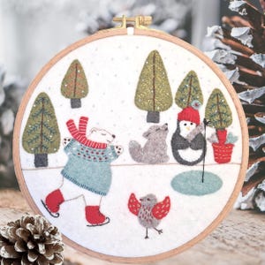 May include: A white polar bear wearing a blue and red sweater and red ice skates is skating on a white snowy surface. A grey wolf, a penguin wearing a red hat, and a red bird are also on the snowy surface. There are green trees in the background.