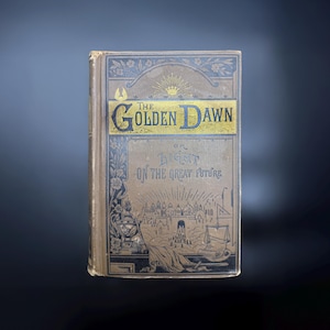 May include: The cover of a vintage book titled "The Golden Dawn or Light on the Great Future". The cover is brown with gold lettering and an illustration of a city with a gate and a crown.