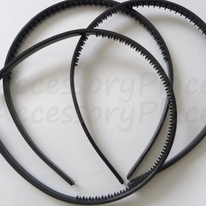 May include: Three black plastic headbands with a textured edge. The headbands are stacked on top of each other.