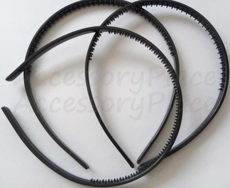 May include: Three black plastic headbands with a textured edge. The headbands are stacked on top of each other.