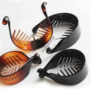 May include: Four hair clips, two brown and two black, with a comb-like design on the inside of the curved shape. The clips are made of plastic.