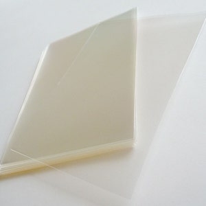 May include: A stack of clear plastic sheets, likely for crafting or protecting documents.