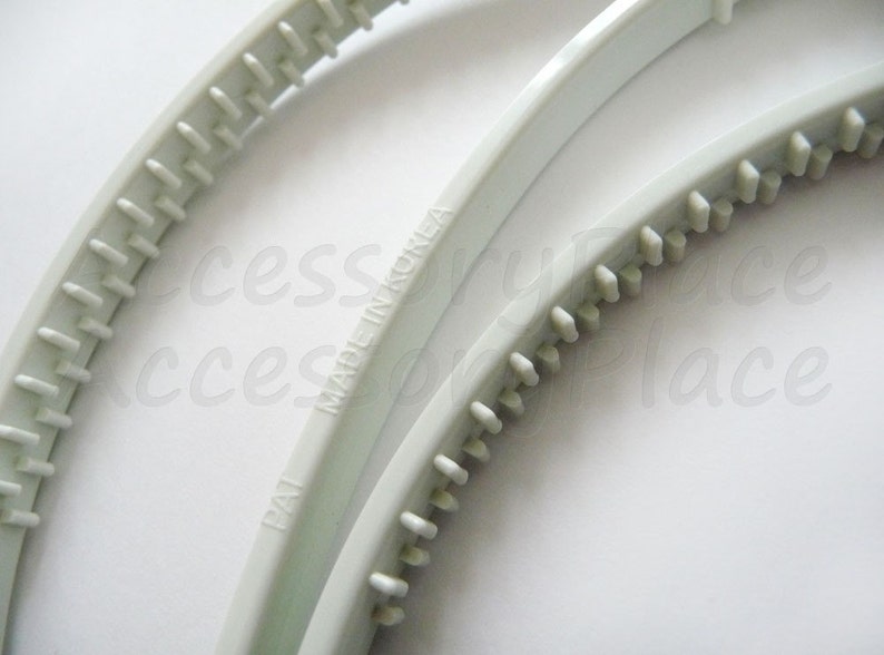May include: Two white plastic hair bands with a textured grip. The bands are made in Korea and have the text "Made in Korea" printed on them.