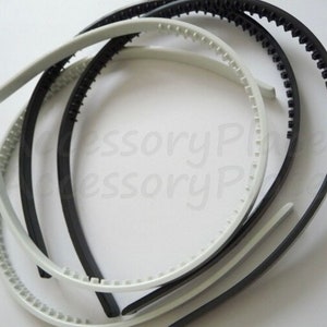 May include: A set of four plastic headbands, two black and two white. The headbands have a textured, ridged surface for grip.