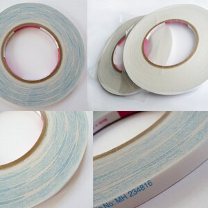 May include: A roll of double-sided adhesive tape featuring a white backing with a light blue marbled pattern. The inner cardboard core is brown, and the side of the tape is printed with the text SOOKWANG and the product code File No: MH 234816.