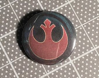 May include: A red and black Rebel Alliance symbol button. The button is round and has a glossy finish.