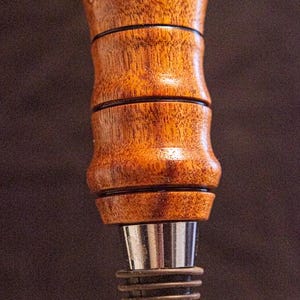 Handmade wooden wine bottle stoppers hand turned from exotic wood with stainless steel.