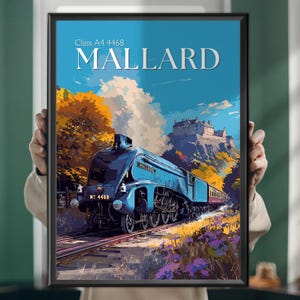 Op de afbeelding: Een ingelijste print van de blauwe stoomtrein Mallard, met een landschap met een kasteel en herfstbomen. De print bevat de tekst "MALLARD" en "Class A4 4468". De lucht is blauw.
