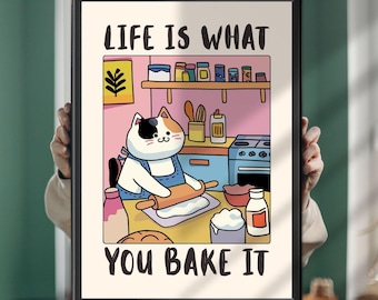 May include: A framed wall art print featuring a cartoon calico cat wearing an apron and using a rolling pin on dough in a kitchen. The text LIFE IS WHAT YOU BAKE IT is printed in black at the top and bottom of the illustration with colorful kitchen items.