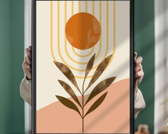 Può includere: Una stampa artistica incorniciata con un'illustrazione centrale di una foglia botanica marrone scuro. Sopra la foglia c'è un cerchio arancione solido circondato da linee ad arco gialle concentriche. Lo sfondo è color crema con una forma curva color pesca.