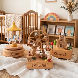 May include: Three wooden music boxes featuring a carousel with a unicorn, a Ferris wheel with animal figures, and a castle. The bases are engraved with the names Liam, Olivia, and Oliver, with a butterfly icon next to the name Olivia.