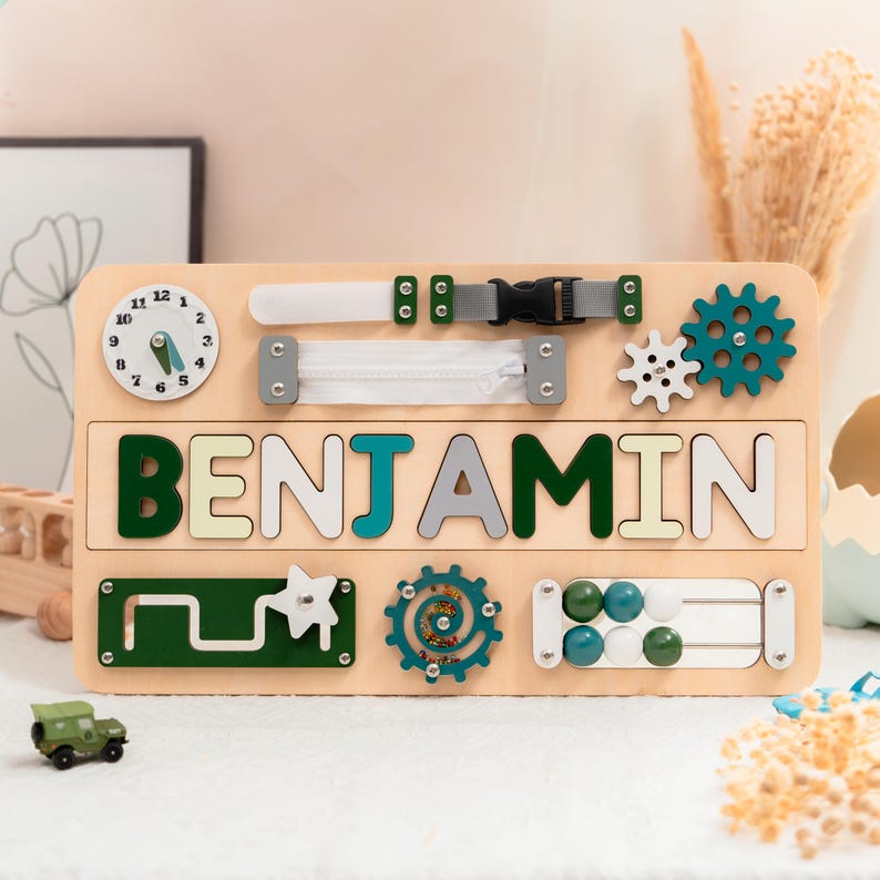 A wooden name board with the name "BENJAMIN" displayed on it, surrounded by various colorful and interactive toys and accessories.
