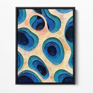 May include: A framed abstract wall art piece featuring a layered, topographical design with deep navy blue, vibrant turquoise, and light cream-colored organic shapes that create a sense of depth and dimension within a black rectangular frame.