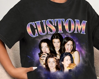 May include: Black t-shirt with a graphic featuring five women and the word "CUSTOM" in a colorful, retro font. The women are set against a purple and blue galaxy-like background.