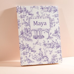 May include: A white journal with a purple toile pattern and the name "Maya" printed on the front.
