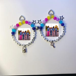 May include: Two beaded bracelets with photos, text, and charms. One bracelet says "LOVE U MEAN IT" and has a lock charm. The other says "HATE U KIDDING" and has a key charm. The bracelets have colorful beads and star charms.