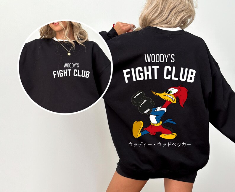 a woman wearing a black sweatshirt with a cartoon character on it